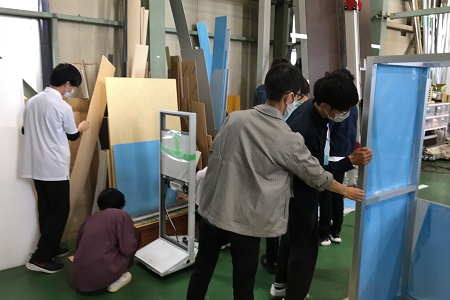 千葉大学意匠展2021メンバーに看板の工場を案内している様子